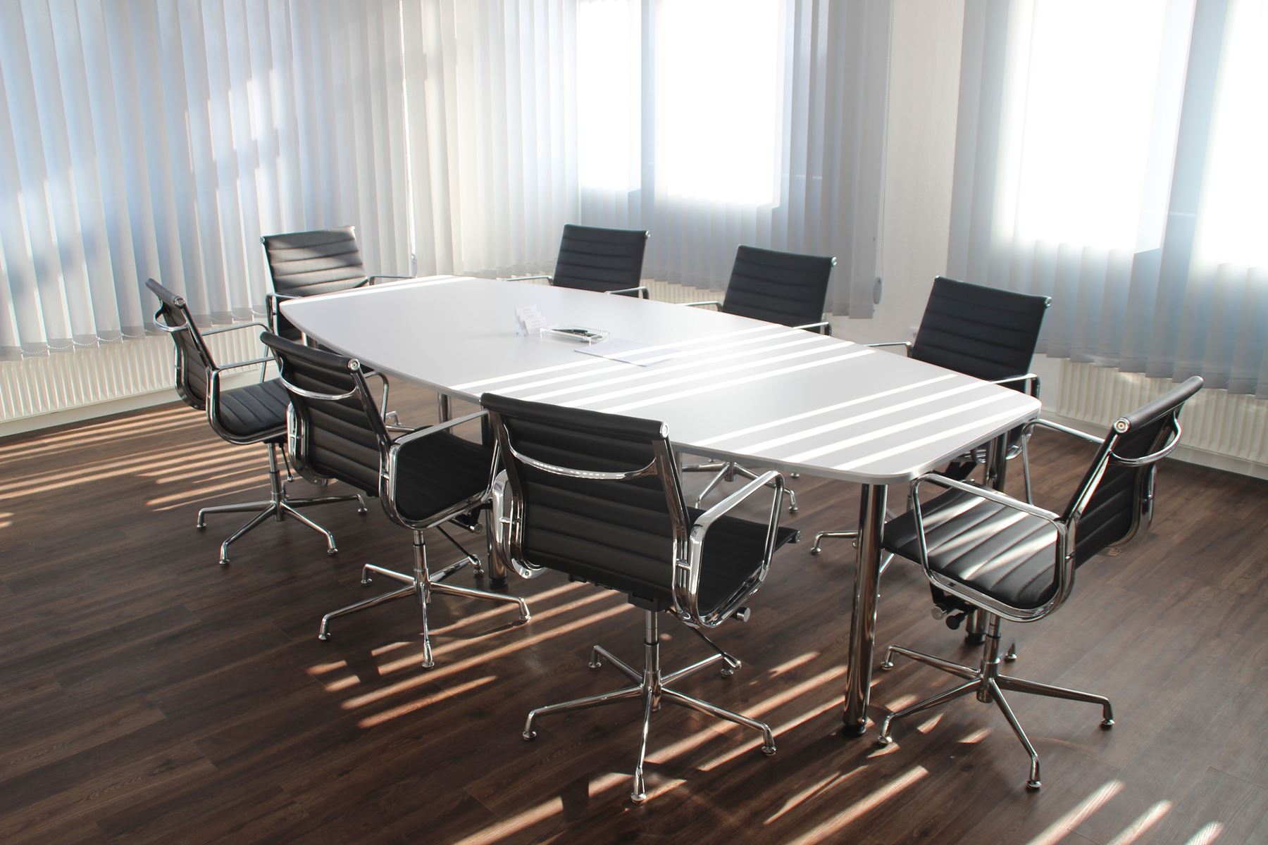 Conference table with chair around it. The room is empty and full of sunshine