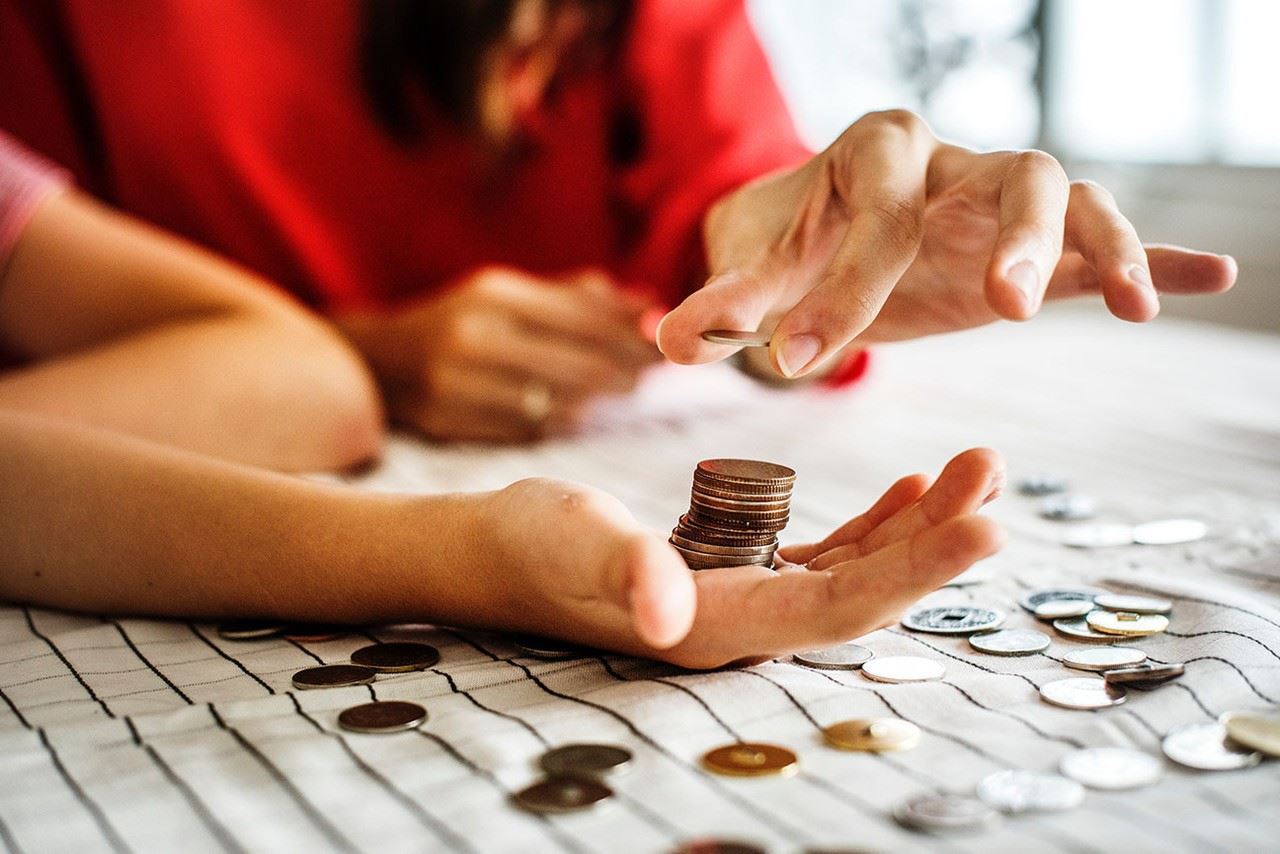 Woman stacking coins in someones hand